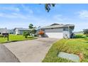 House exterior showcasing a driveway and water view at 1437 Grand Cayman Cir, Winter Haven, FL 33884