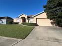 Front view of a one-story house with a two-car garage and neat landscaping at 9260 Winchester Estates Blvd, Lakeland, FL 33810