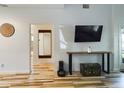 Modern living room with wood-look tile floors and large TV at 2049 San Marcos Se Dr # 127, Winter Haven, FL 33880