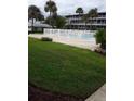 Community pool with grassy area and palm trees at 1700 6Th Nw St # C7, Winter Haven, FL 33881