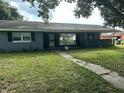 Gray house with mature tree and a grassy front yard at 100 Stevenson Rd, Winter Haven, FL 33884