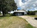 House exterior with driveway and mature tree at 100 Stevenson Rd, Winter Haven, FL 33884
