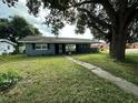 Gray house with mature tree and a grassy front yard at 100 Stevenson Rd, Winter Haven, FL 33884