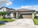 One-story house with a brown garage door, landscaping and palm trees at 278 Alford Dr, Davenport, FL 33896