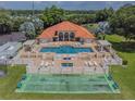 Community pool with surrounding patio and shuffleboard courts at 142 Morning Glory Cir, Winter Haven, FL 33884