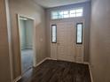 Bright entryway with white door and dark flooring at 991 First Dr, Eagle Lake, FL 33839