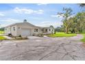 Newly renovated home with white brick exterior, landscaping, and a spacious lawn at 5303 Tillman Rd, Lakeland, FL 33810