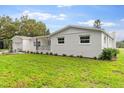 Newly renovated home with white brick exterior, landscaping, and a spacious lawn at 5303 Tillman Rd, Lakeland, FL 33810