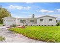 Newly renovated home with white brick exterior, landscaping, and a spacious lawn at 5303 Tillman Rd, Lakeland, FL 33810
