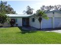 Single-story house with a two-car garage and a lawn at 2201 W Pilaklakaha Ave, Auburndale, FL 33823