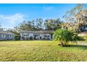 Ranch style home with a spacious yard and palm tree at 2221 W Pilaklakaha Ave, Auburndale, FL 33823