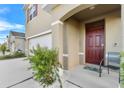Inviting entryway with a red door and landscaping at 112 Sofia Ln, Lake Alfred, FL 33850