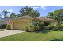 Single story home with attached garage and lush landscaping at 466 Muirfield Ct, Winter Haven, FL 33884