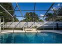 Relaxing swimming pool with screened enclosure and stone waterfall at 672 Wakulla Dr, Winter Haven, FL 33884