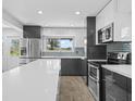 Modern kitchen with white countertops, gray cabinets, and stainless steel appliances at 430 N Omaha St, Lake Hamilton, FL 33851