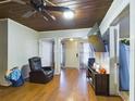 Living room with wood flooring, a recliner, and a large TV at 3511 Avenue R Nw, Winter Haven, FL 33881