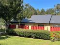 Condo exterior with red fence and landscaping at 1039 Medinah Dr, Winter Haven, FL 33884