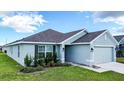 One-story house with light green exterior, landscaping, and two-car garage at 1274 Zambrana Ct, Winter Haven, FL 33884