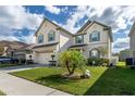Two-story house with a palm tree and well-maintained lawn at 940 Waterville Dr, Auburndale, FL 33823