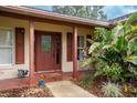 Inviting front entrance with a decorative glass door and lush tropical plants at 1937 Rifle Range Rd, Winter Haven, FL 33880
