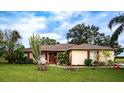 Ranch style home with brown roof and red accents sits on a large grassy lot at 1957 Rifle Range Rd, Winter Haven, FL 33880