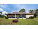 Large screened porch overlooks a spacious backyard with fire pit at 1957 Rifle Range Rd, Winter Haven, FL 33880