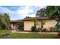 Tan house with red shutters and lush landscaping at 1957 Rifle Range Rd, Winter Haven, FL 33880