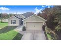 One-story house with a two-car garage and landscaped lawn at 230 Grouper Ct, Poinciana, FL 34759