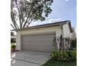 Attached garage with taupe overhead door and landscaping at 4163 Pirates Lndg, Winter Haven, FL 33884