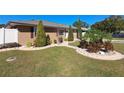 Landscaped front yard with tan house and walkway at 1905 16Th Nw St, Winter Haven, FL 33881