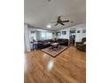 Spacious living room with hardwood floors, ample seating, and a ceiling fan at 312 Douglas Park Ave, Davenport, FL 33897