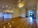 Bright living room with hardwood floors, ceiling fan, and access to the kitchen at 4152 Aberdeen Ln, Lake Wales, FL 33859