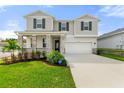Two-story house with gray siding, stone accents, and a two-car garage at 9660 Westside Hills Dr, Davenport, FL 33896