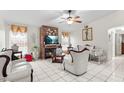 Living room with white furniture, fireplace, and a ceiling fan at 1028 Dampierre Ct, Kissimmee, FL 34759