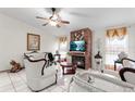 Living room features a fireplace, white furniture, and a ceiling fan at 1028 Dampierre Ct, Kissimmee, FL 34759