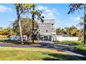 Gray two-story house with a metal roof, and a gated entrance at 128 Caloosa Dr, Babson Park, FL 33827