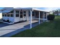 Side view of a white mobile home with carport and well-maintained lawn at 161 Bonnie Dr, Auburndale, FL 33823