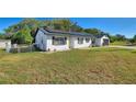 Front view of a charming white brick house with solar panels and a grassy yard at 1610 Meadow Ne Ln, Winter Haven, FL 33881