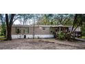 Tan mobile home with covered deck and surrounding trees at 2419 Trenton E Rd, Lakeland, FL 33815