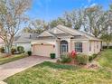 Tan house with a two-car garage and neatly landscaped yard at 2985 Pinnacle Ct, Clermont, FL 34711