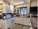 Bright kitchen with white cabinets and appliances at 703 Lake Ada Blvd, Dundee, FL 33838