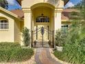 Elegant entryway with wrought iron gate and a charming walkway at 1072 Old Cutler Rd, Lake Wales, FL 33898