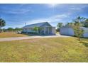 Gray house with metal roof, large yard, and detached garage at 118 Acacia Walk, Lake Wales, FL 33898