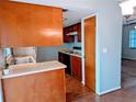Kitchen with wood cabinets, double sink, and doorway to another room at 16 Kendra Ct # 16, Winter Haven, FL 33880