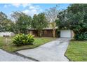 House with a large front yard, driveway, and mature trees at 1891 18Th Nw St, Winter Haven, FL 33881