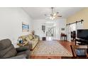 Cozy living room with wood floors, ceiling fan, and sliding barn door at 221 Prather Dr, Davenport, FL 33837