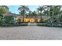 Elegant home with a brick driveway and palm trees at dusk at 2300 N Scenic Hwy # 104, Lake Wales, FL 33898