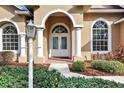 Arched entryway with double doors, white columns, and brick walkway at 231 Terranova Blvd, Winter Haven, FL 33884