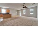 Open living room and kitchen with carpeted floor and ceiling fan at 3803 Wind Dancer Cir, Saint Cloud, FL 34772