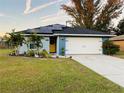 Newly built home with solar panels, landscaped yard, and two-car garage at 707 E Frederick Ave, Dundee, FL 33838